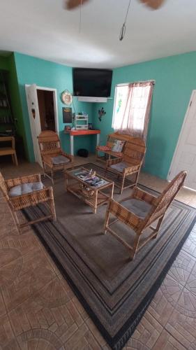 a living room with chairs and a table and a tv at Castaways Villa in Duncans
