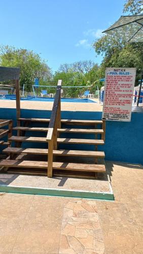 a set of wooden stairs with a sign next to it at Castaways Villa in Duncans