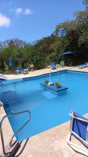 a large swimming pool with blue water and chairs at Castaways Villa in Duncans