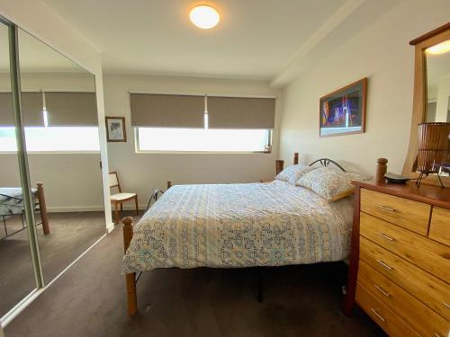 - une chambre avec un lit et une commode dans l'établissement Beach Life, à Aspendale