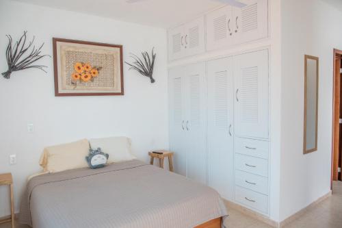 a white bedroom with a bed and a dresser at Casa privada con alberca grande in Chetumal