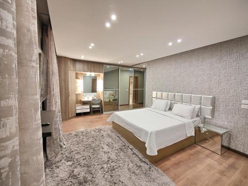 1 Schlafzimmer mit einem weißen Bett und einem Badezimmer in der Unterkunft Luxury Duplexe in Beverly Hills in Sheikh Zayed
