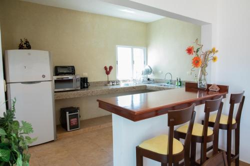 a kitchen with a white refrigerator and a counter top at Casa privada con alberca grande in Chetumal