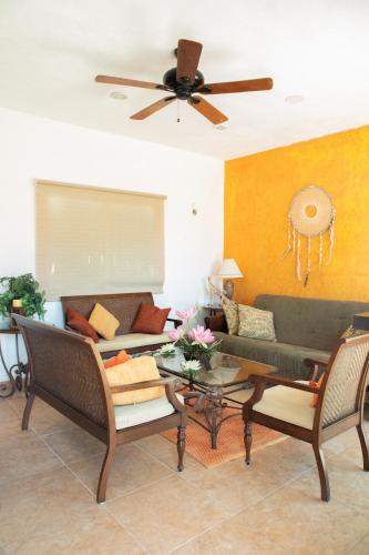 a living room with a couch and a ceiling fan at Casa privada con alberca grande in Chetumal