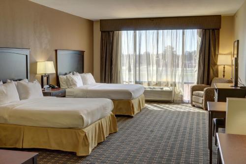 ein Hotelzimmer mit 2 Betten und einem großen Fenster in der Unterkunft Holiday Inn Express Hotel & Suites Texarkana East, an IHG Hotel in Texarkana