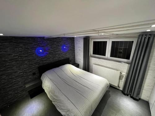 una camera con un letto bianco e un muro di mattoni di Les hirondelles a Battenheim