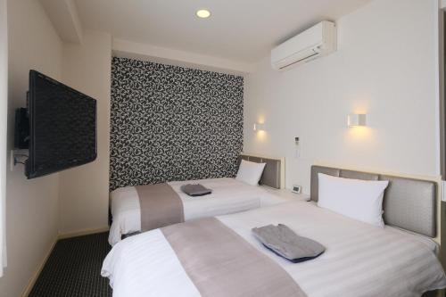福山福山东方酒店的酒店客房设有两张床和一台平面电视。