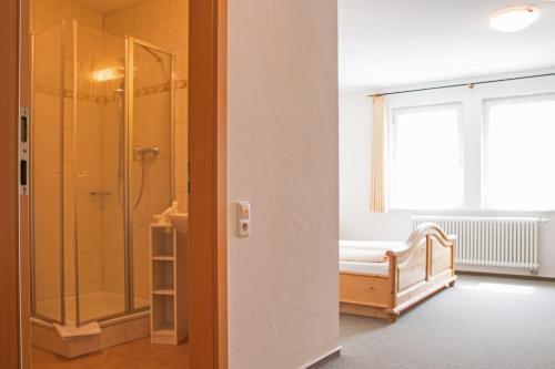 a bathroom with a shower and a bed and a window at Gasthaus Kreuz in Ühlingen-Birkendorf