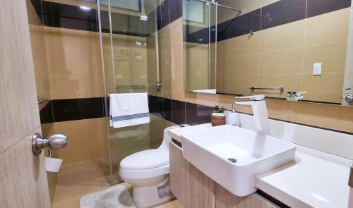 y baño con lavabo, aseo y espejo. en Apartamento en santa marta pozos colorados Samaria club de playa, en Santa Marta