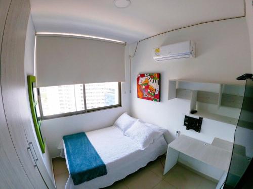 niewielka sypialnia z łóżkiem i oknem w obiekcie Apartamento en santa marta pozos colorados Samaria club de playa w mieście Santa Marta