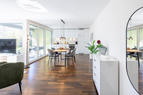 a kitchen and dining room with a table and chairs at STAYY Green Oasis near Zurich I free Parking I TV in Dietikon