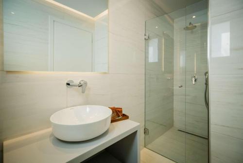 a white bathroom with a sink and a shower at Agios Sostis Harbour View in Laganas