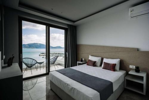 a bedroom with a bed and a view of the ocean at Agios Sostis Harbour View in Laganas