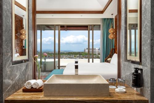 a bathroom with a sink and a large window at Fairmont Sanya Haitang Bay in Sanya