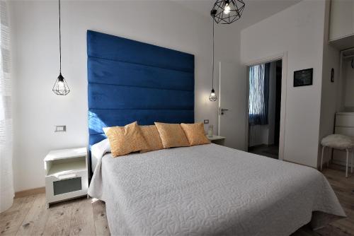 a bedroom with a large bed with a blue headboard at La Villa di Nonna Pina in Balestrate