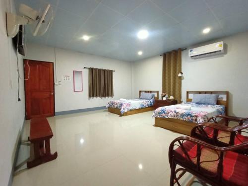 Habitación con 2 camas, mesa y sillas en Muangchaem House, en Mae Chaem