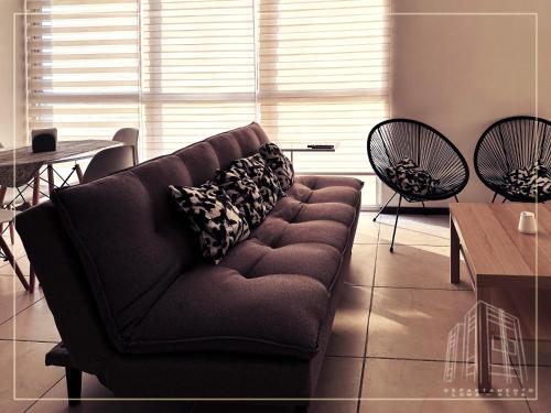 a couch in a living room with a table and chairs at Departamento Loma-Alta in Guadalajara