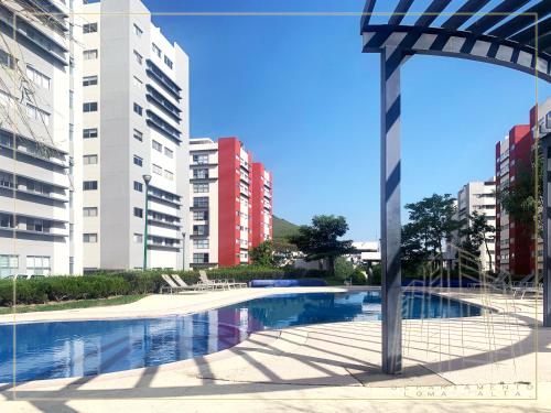 a swimming pool in a city with tall buildings at Departamento Loma-Alta in Guadalajara