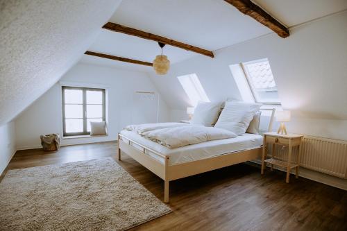 - une chambre blanche avec un lit et un tapis dans l'établissement Fritz im Glück, à Rietberg