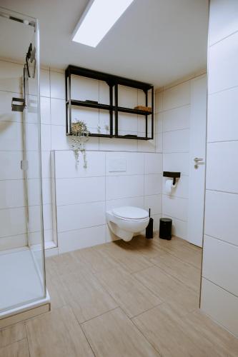 ein Badezimmer mit Toilette und Glasdusche in der Unterkunft Fritz im Glück in Rietberg