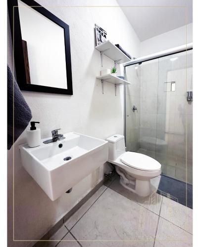 a white bathroom with a sink and a toilet at Departamento Loma-Alta in Guadalajara