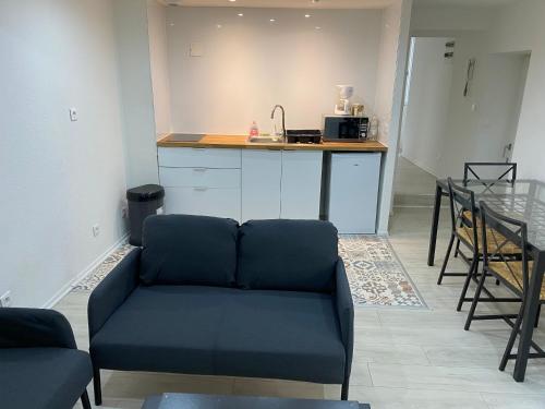 un salon avec un canapé et une cuisine dans l'établissement Appartement 2ème étage 42m2 hyper centre ville / parking gratuit, à Riom