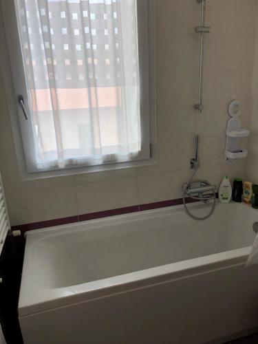 baño con bañera blanca y ventana en Kasia porta sul mare di Livorno Free parking, en Livorno