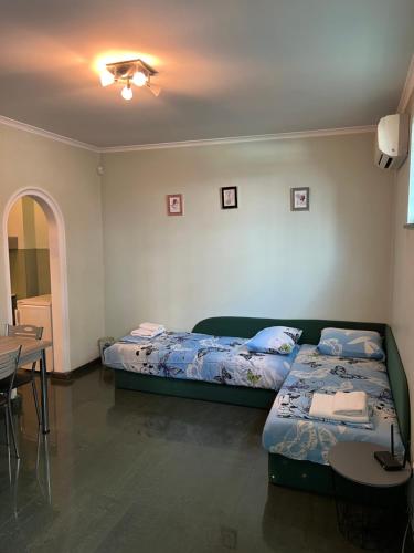 a bedroom with two beds and a table and a table and chairs at Sunny in Haskovo