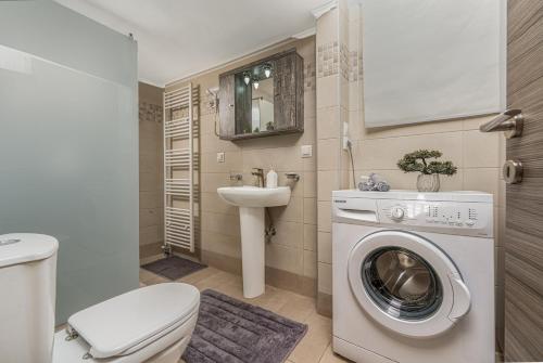 ein Badezimmer mit Waschmaschine und Waschbecken in der Unterkunft Little Gem in Zakynthos