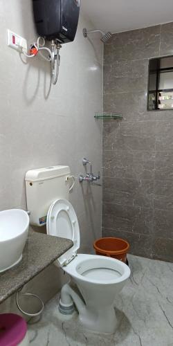 a bathroom with a toilet and a sink at Nivaant @ Vicharays in Alibaug