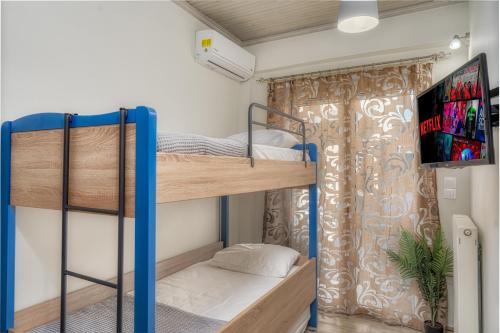 Zimmer mit 2 Etagenbetten und einem Flachbild-TV in der Unterkunft Little Gem in Zakynthos