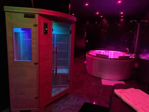 a pink bath tub in a room with purple lights at Appartement 1er Etage 42m2 hyper centre ville / parking gratuit in Riom