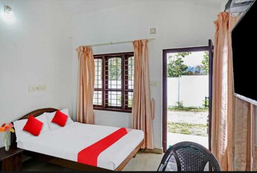 a bedroom with a bed and a large window at Mountain View cottage Mankulam in Munnar