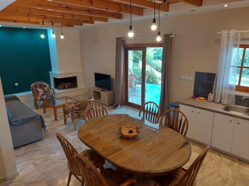 a kitchen and living room with a wooden table and chairs at Amelia's Garden in Kavos