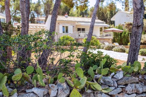 un patio con una casa, árboles y una pared de piedra en Holiday House de Finis, en Sutivan