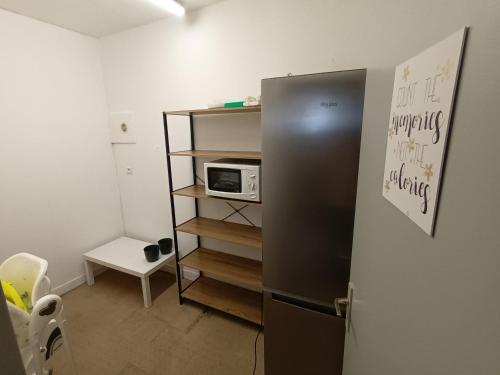 a kitchen with a refrigerator and a microwave at Le Miraillet, gîte in Saint-Illide
