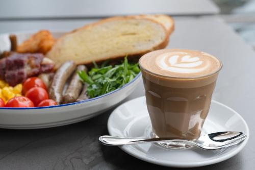 迪拜Oaks Liwa Heights Hotel Suites的盘子里的咖啡,加上一碗食物