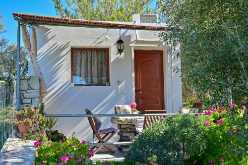a cottage with a red door and a balcony at To Spiti Tou Papa Sto Vouno in Kamilari