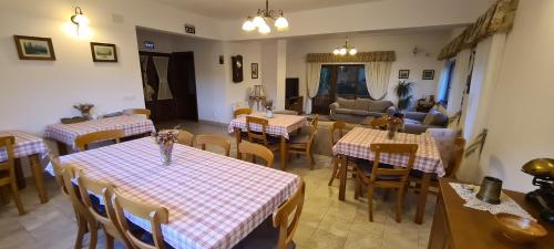 a restaurant with tables and chairs and a living room at Arnica Montana in Arieşeni