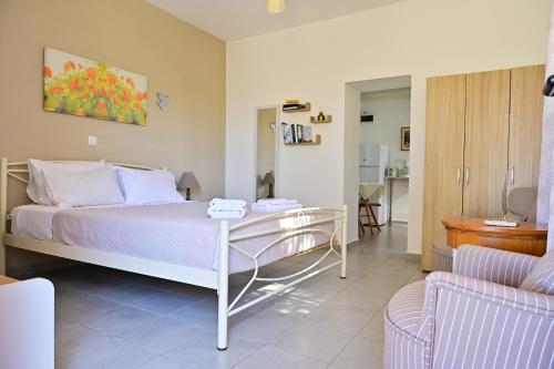 a bedroom with a bed with a table and a couch at To Spiti Tou Papa Sto Vouno in Kamilari
