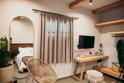 1 dormitorio con cama y escritorio con espejo en ANDROMEDA, en Kalymnos