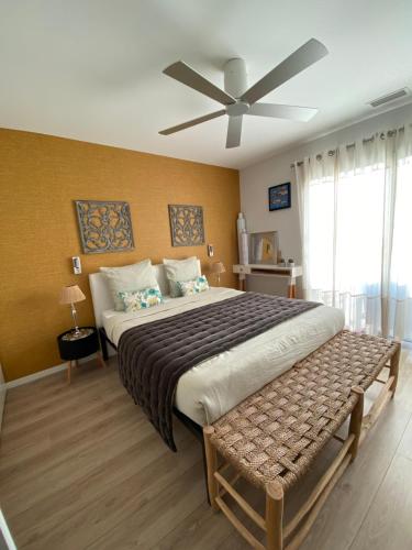 - une chambre avec un grand lit et un ventilateur de plafond dans l'établissement Escapades Lointaines, à Perpignan