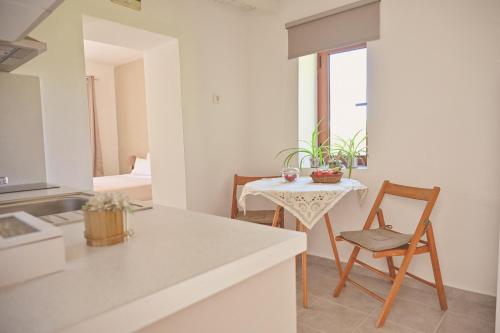 a kitchen and living room with a table and a chair at To Spiti Tou Papa Sto Vouno in Kamilari