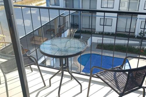 a balcony with a table and chairs and a swimming pool at Confortable depto con alberca in Zapopan