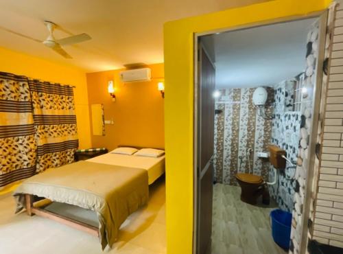 1 dormitorio con cama y pared amarilla en Samantha Inn Beach Resort, en Arambol