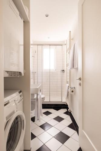 a bathroom with a washing machine and a sink at EMA House Serviced Apartments Superior Seefeld in Zürich
