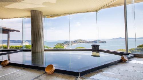 a swimming pool with a view of the water at Tenku Hotel Kairo in Tonosho