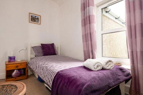 a bedroom with a bed and a window at Miners Cottage in Blaenau-Ffestiniog