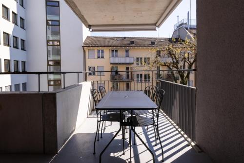 balcone con tavolo e sedie. di EMA House Serviced Apartments Superior Seefeld a Zurigo