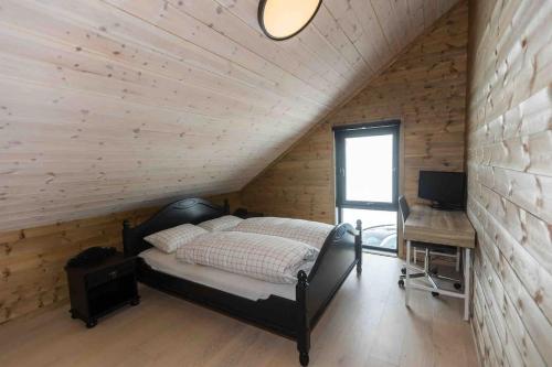 Dormitorio con cama y escritorio en el ático en New Holiday cottage with jacuzzi and sauna en Tjørhom